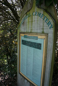 A sign reading Hallowell Cemetery with a plaque beneath the words. 